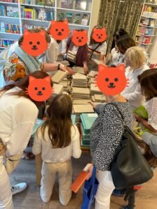 Lesekatze - Eine Gruppe von Menschen stöbert in einer Buchhandlung und wählt Bücher aus.