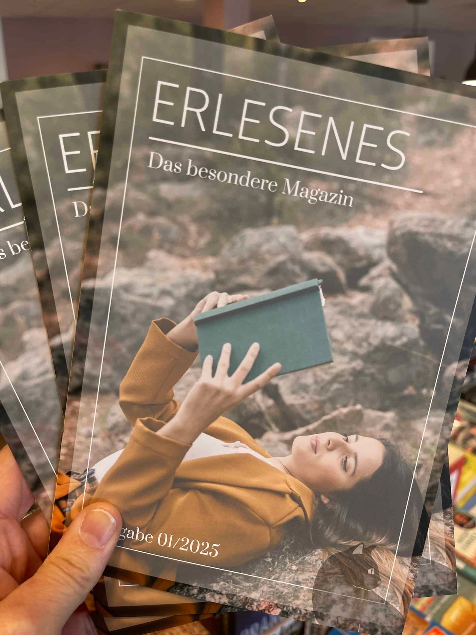 Lesekatze - Woman reading "Erlesen" magazine outdoors. Ausgabe 01/2025